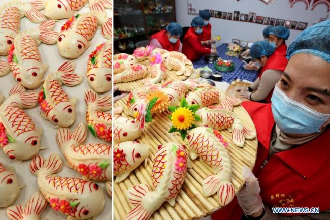 Před lunárním Novým rokem v Zaozhuang (Cao-čuang) ve východočínské provincii Shandong (Šan-tung), 2. února 2021, dobrovolníci dělají knedlíky ve tvaru ryb, které symbolizují hojnost. Lunární Nový rok patří k nejvýznamnějším svátkům v Číně a oslavné činnosti jsou rozmanité, včetně jídla. Když přichází lunární Nový rok, lidé po celé Číně připravují různá občerstvení, která, jak věří, jim přinesou štěstí. (Foto: Sun Zhongzhe / Xinhua)