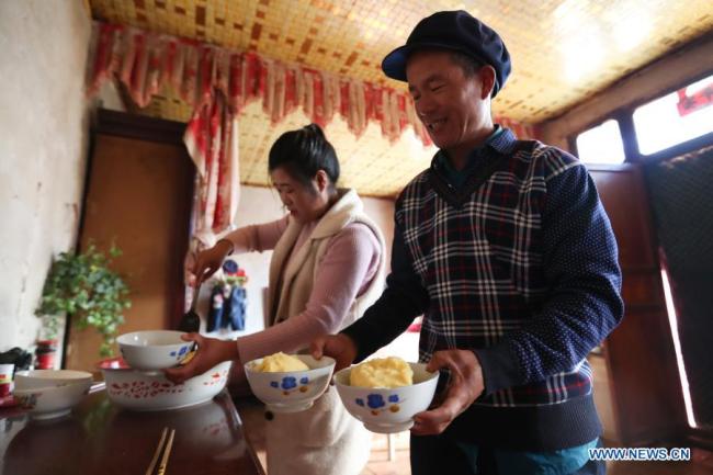 Vesničané dělají Jiaotuan (Ťiao-tchuan), místní lunární novoroční svačinu ze šťouchaných brambor a podávanou s kořením, ve vesnici Yuangudui (Jüan-ku-tuej) v okrese Weiyuan (Wej-jüan) v provincii Gansu (Kan-su) na severozápadě Číny, 6. února 2021. Lunární Nový rok patří k nejvýznamnějším svátkům v Číně a oslavné činnosti jsou rozmanité, včetně jídla. Když přichází lunární Nový rok, lidé po celé Číně připravují různá občerstvení, která, jak věří, jim přinesou štěstí. (Xinhua / Ma Xiping)