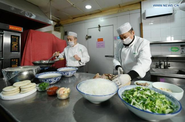 Wu Ping (Wu Pching, vpravo) připravuje typická regionální jídla v restauraci v Xi'an v provincii Shaanxi na severozápadě Číny, 2. ledna 2021. (Xinhua / Li Yibo)