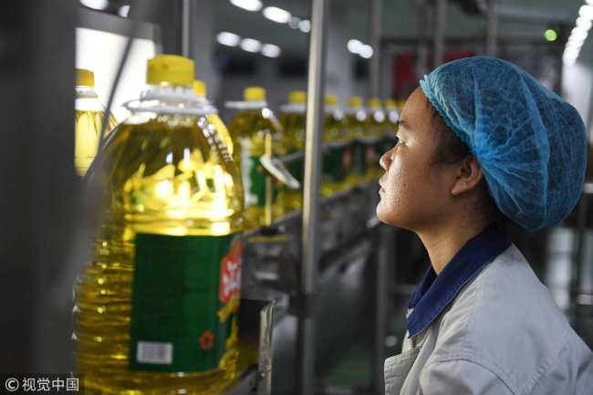 19 de julio de 2018: un trabajador que monitorea una línea de producción de aceite de soja en la fábrica. La compañía actualmente usa soja importada de Brasil. / VCG Photo