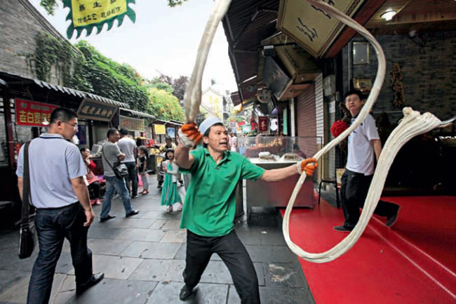 Un cocinero luce su técnica en la calle musulmana de Xi'an