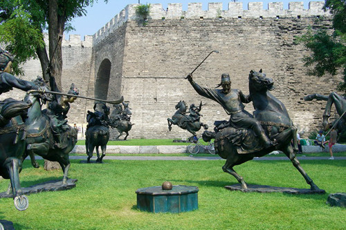 Estatuas de jinetes que juegan el polo, bajo la muralla restaurada de la ciudad de Beijing