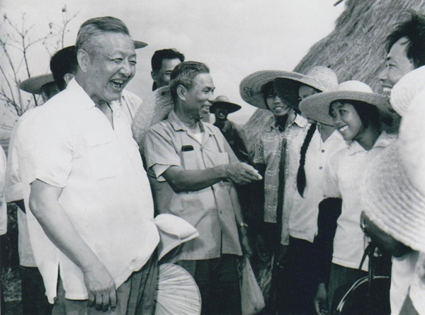 Desde finales de agosto hasta principios de septiembre de 1980, Xi Zhongxun (primero por la izquierda) mantuvo una conversación cordial con los jóvenes durante una inspección en las zonas rurales de la ciudad de Zhanjiang, provincia de Guangdong.
