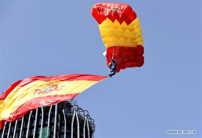  Un parachutiste survole Madrid avec un drapeau espagnol pour célébrer la fête nationale, à Madrid, capitale espagnole, le 12 octobre 2017. L'Espagne a organisé jeudi un défilé traditionnel à Madrid pour célébrer sa fête nationale. (Photo: Guo Qiuda)