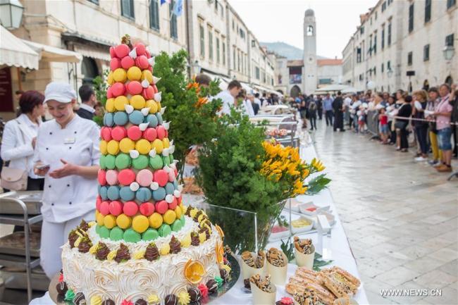 Des personnes attendent de déguster des plats lors du Festival des bons aliments, à Dubrovnik, en Croatie, le 22 octobre 2017. La clôture de ce festival de quatre jours a été marquée dimanche par la "Table de Dubrovnik", s'étendant le long de la Rue de Stradun, dans la vieille ville. (Photo : Grgo Jelavic)