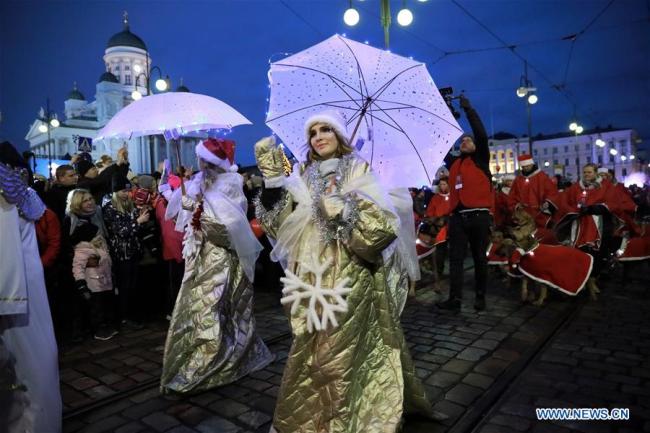 La foule dans une rue illuminée à Helsinki en Finlande, le 26 novembre 2017. Une cérémonie traditionnelle a été organisée dimanche dans le centre-ville d'Helsinki pour fêter le début de la saison de Noël. (Photo : Li Jizhi)