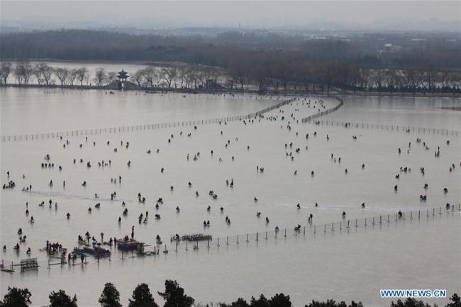 Des gens s'amusent sur la surface gelée du lac Kunming, au Palais d'été, à Beijing, capitale chinoise, le 7 janvier 2018. (Liu Xianguo)