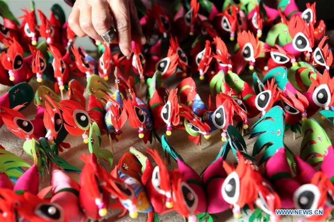Une employée fait des nœuds chinois en préparation de la Fête du Printemps à venir à Linyi, dans la province du Shandong (est de la Chine), le 11 janvier 2018. La Fête du Printemps, ou le Nouvel An lunaire chinois, tombera cette année le 16 février. (Xinhua/Zhang Chunlei)