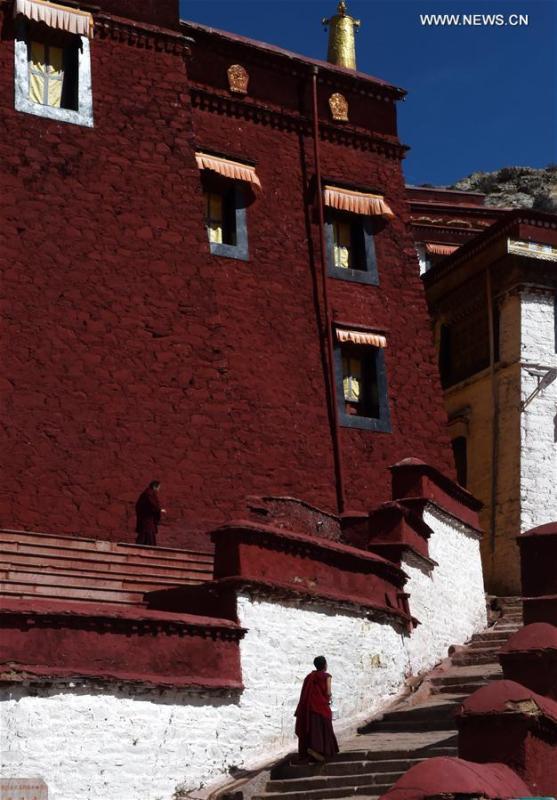 Des moines passent devant la salle des Écritures du Temple Gandan à Lhassa, capitale de la région autonome du Tibet (sud-ouest de la Chine), le 9 mars 2018. Fondé en 1409 par les disciples de Zong Kaba, fondateur de la secte jaune du bouddhisme tibétain, le temple Gandan est le plus ancien parmi toutes les lamaseries de la Secte Jaune.