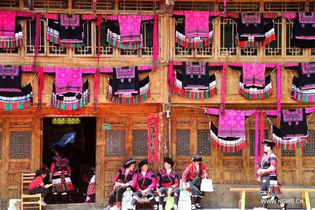  Des vêtements brodés aux couleurs vives suspendus aux maisons par des femmes de l'ethnie Yao pour célébrer la fête "San Yue San" à Huangluo, village du bourg de Longji à Longsheng, dans la région autonome Zhuang du Guangxi (sud de la Chine), le 18 avril 2018. (Photo : Wang Zichuang) 
