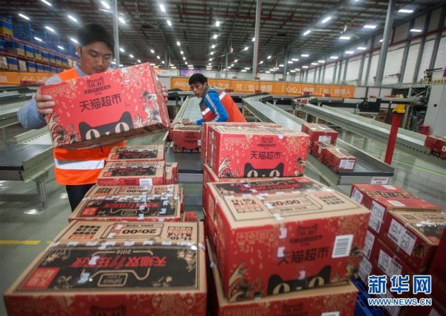 Des ouvriers déplacent des colis dans un centre de stockage automatique et intelligent ouvert par Cainiao Network Technology à Guangzhou, dans la province du Guangdong. [Crédit photo : Xinhua]