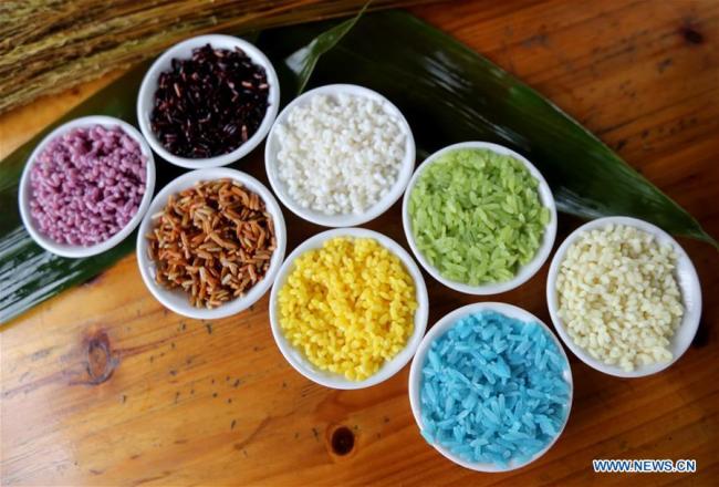 Des ingrédients pour préparer des zongzi colorés, gâteaux de forme pyramidale composés de riz gluant emballé dans des feuilles de bambou ou de roseau, à l'approche de la Fête des bateaux-dragons, dans le district de Rong'an de la région autonome Zhuang du Guangxi (sud), le 12 juin 2018. (Photo : Tan Qinghe)