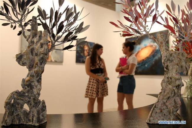 Des visiteurs regardent des oeuvres d'art lors de l'événement Art Athina à Athènes, en Grèce, le 23 juin 2018. L'événement est l'une des plus anciennes foires d'art de l'Europe. (Xinhua/Marios Lolos)