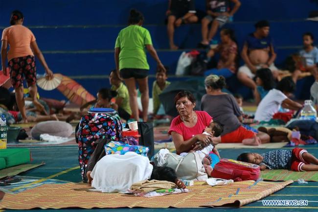  Des habitants se réfugient temporairement dans un terrain de basket couvert à cause des inondations apportées par la tempête tropicale Son-Tinh à Quezon City aux Philippines, le 18 juillet 2018. (Photo : Rouelle Umali)