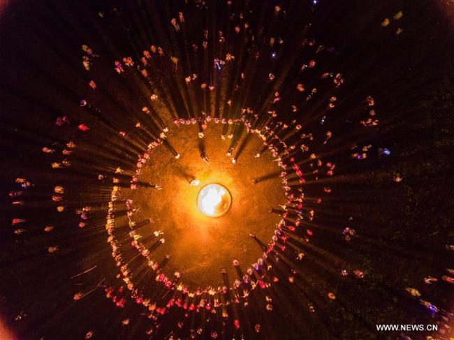 Des participants allument des torches lors de la fête des Torches de l'ethnie Yi dans le district de Zhaojue de la province du Sichuan (sud-ouest de la Chine), le 5 août 2018. Des membres de l'ethnie Yi et des touristes ont dansé et chanté ensemble pour célébrer l'événement. (Photo : Lyu Mingze)
