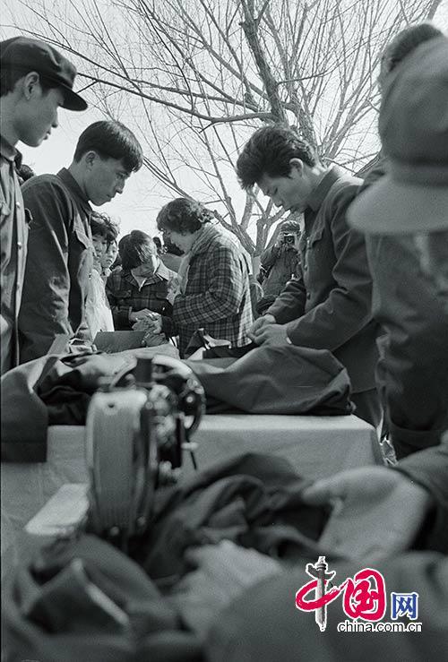 Photo prise en 1978. Des tailleurs indépendants confectionnent des vêtements pour les clients dans une foire.