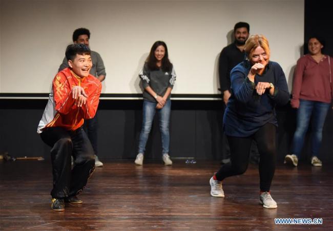 Shi Longlong (devant à gauche), un enseignant de l'Université d'éducation physique et des sports de la capitale, une institution qui se trouve à Beijing, explique des mouvements de kung-fu à une femme turque à l'Université du Bosphore d'Istanbul, en Turquie, le 9 octobre 2018. La tournée Charme du kung-fu chinois a débuté mardi soir à l'Université du Bosphore d'Istanbul, enchantant le public avec un mélange d'arts martiaux chinois et de danses. 