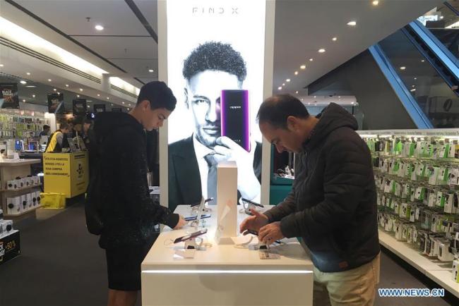 Des gens choisissent des smartphones OPPO dans un centre commercial de Barcelone, en Espagne, le 25 novembre 2018.