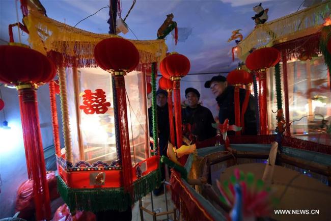 Des commerçants regardent des zootropes lumineux, dans le village de Wangqiao du bourg de Gangshang, dans le district de Tancheng de la ville de Linyi, dans la province chinoise du Shandong (est), le 11 janvier 2019. Cette sorte de lanterne traditionnelle chinoise projette des images en rotation et donne l'illusion d'un mouvement continu. Selon la tradition locale, les habitants fabriquent ces lanternes pour célébrer le Nouvel An lunaire chinois. (Photo : Fang Dehua)