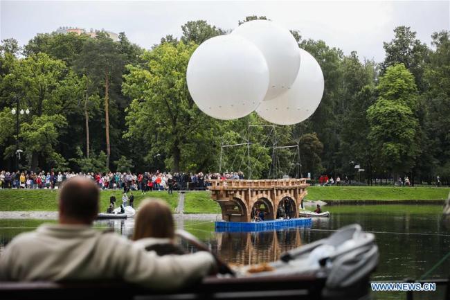 Des personnes regardent un pont volant fait de carton et de scotch dans le parc Ostankino, à Moscou, en Russie, le 1er août 2019. Un pont volant long de 18 mètres, composé de carton et de scotch, a été assemblé et installé jeudi dans le parc Ostankino de Moscou. Le pont a été soulevé dans les airs à l'aide de trois ballons d'hélium. (Photo : Maxim Chernavsky)