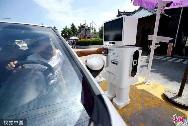 Le 30 juillet, un robot intelligent a été installé dans le parking du site du temple de Baima, à Luoyang, dans la province du Henan. Grâce à un système d'identification automatique, le robot offre de multiples services, dont le paiement électronique ou en cash et l’impression de factures. (Photos : VCG)