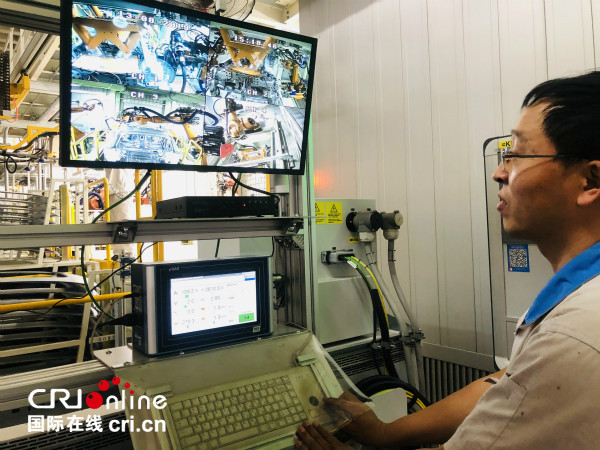 Les travailleurs voient l'état de fonctionnement du robot de soudage au laser à travers l'écran d'affichage