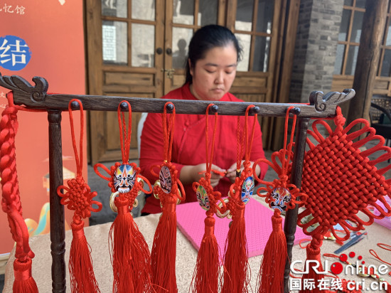 Une artisane en train de tricoter un nœud chinois