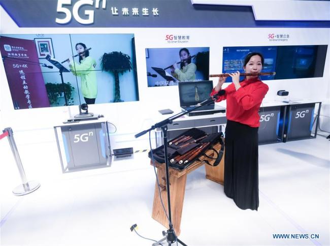Un membre du personnel présente de l’enseignement musical à distance soutenu par les technologies 5G et 4K au centre d'exposition « Lumière de l’Internet » à Wuzhen, dans la province du Zhejiang (est de la Chine), le 19 octobre 2019.