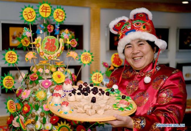 Dang Yaxian, héritière des « petits pains fleuris » traditionnels, montre son travail lors d'une activité d'art populaire de la fête du Printemps organisée à Xi'an, capitale de la province du Shaanxi (nord-ouest de la Chine), le 10 janvier 2020.