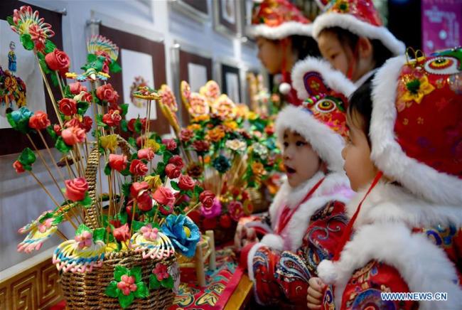 Des enfants regardent des « petits pains fleuris » traditionnels lors d'une activité d'art populaire de la fête du Printemps qui a eu lieu à Xi'an, capitale de la province du Shaanxi (nord-ouest de la Chine), le 10 janvier 2020. Une activité sur le thème des « petits pains fleuris » a eu lieu ici vendredi pour promouvoir l'art populaire dans la partie centrale de la province du Shaanxi à l'approche de la Fête du Printemps. (Liu Xiao / Xinhua)