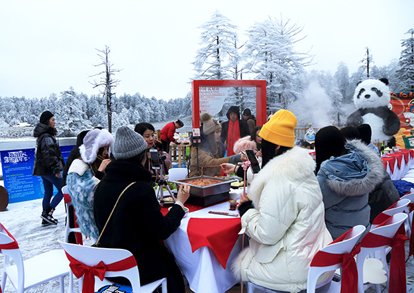 Les touristes mangent du fondu chinois dans la neige