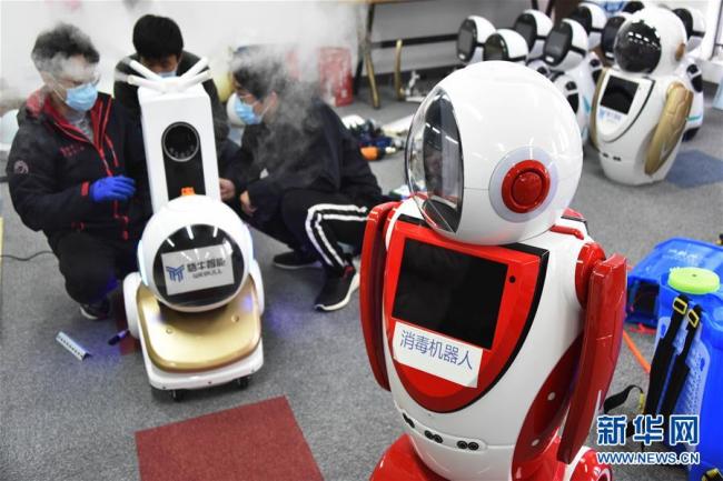Photo prise le 11 février à Qingdao, dans la province chinoise du Shandong, montrant des techniciens en train de régler des robots de désinfections. Ces derniers jours, plusieurs entreprises de Qingdao ont commencé à développer des robots de désinfections pour lutter contre le nouveau coronavirus.