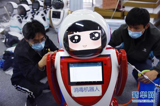 Photo prise le 11 février à Qingdao, dans la province chinoise du Shandong, montrant des techniciens en train de régler des robots de désinfections. Ces derniers jours, plusieurs entreprises de Qingdao ont commencé à développer des robots de désinfections pour lutter contre le nouveau coronavirus.