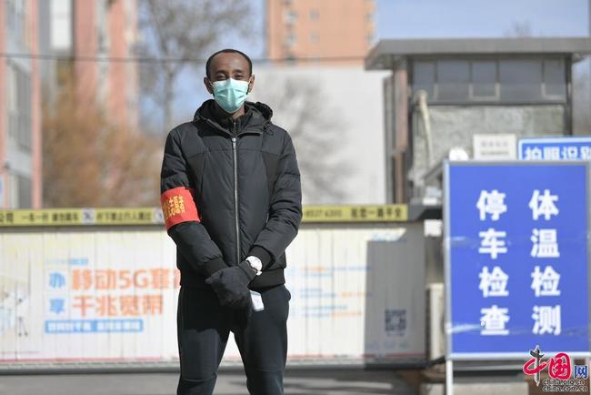 Un jeune Africain sert en tant que bénévole dans un quartier à Beijing pour lutter contre l’épidémie