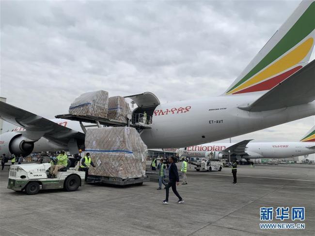 Des employés de l’aéroport en train de décharger du matériel d’aide médicale envoyé par la Chine, le 22 mars, à l’aéroport d’Addis-Abeba.