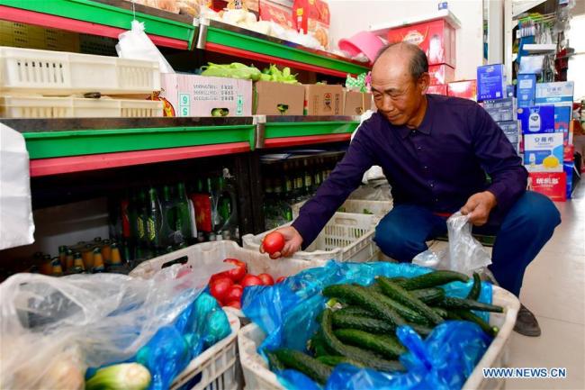 Cao Liuren achète des légumes dans un supermarché de la zone de lutte contre la pauvreté par la relocalisation de Guanghuiyuan, dans le comté de Kelan de la ville de Xinzhou, dans la province du Shanxi (nord de la Chine) le 20 mai 2020.