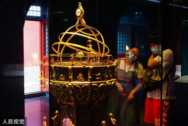 Photo prise le 21 juillet, montrant des visiteurs admirant les cloches antiques conservées dans le palais des horloges au sein du Musée du Palais. 