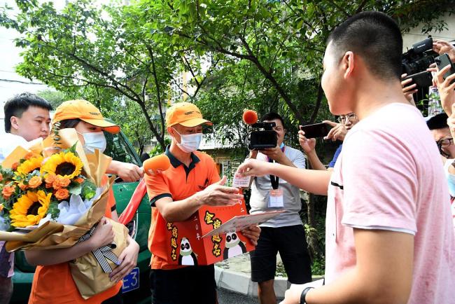 Des employés de la Poste donnent à Li Lingrui le courrier contenant son avis d’amission, le 9 août, à Panzhihua, dans la province du Sichuan.