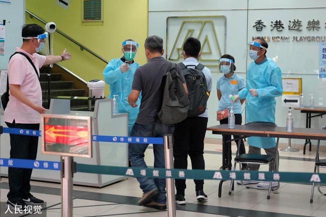 Des habitants subissent un test de COVID-19, le 1er septembre, dans un centre de dépistage installé au Southern Stadium du quartier de Wan Chai, à Hong Kong.