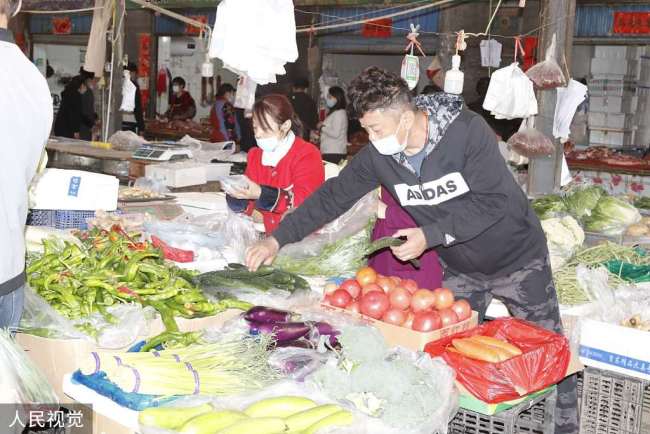 Photos prises le 26 octobre, montrant des habitants en train d’acheter des légumes sur un marché au quartier de Donghu de la préfecture de Kashgar, dans la région autonome ouïghoure du Xinjiang.