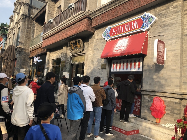 Les gens font la queque devant une boutique de glace à Beijing (Photo crédit: RCI)