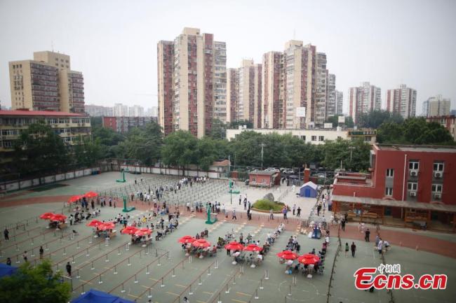 Πολίτες που φορούν μάσκες προσώπου περιμένουν στη σειρά για να λάβουν δοκιμές νουκλεϊκών οξέων στον προσωρινό χώρο δειγματοληψίας σε ένα δημοτικό σχολείο στην περιοχή Τσαογιάνγκ στο Πεκίνο, πρωτεύουσα της Κίνας. Το δημοτικό σχολείο μετατράπηκε προσωρινά σε τόπο δοκιμών νουκλεϊκών οξέων για τους κατοίκους της περιοχής. 