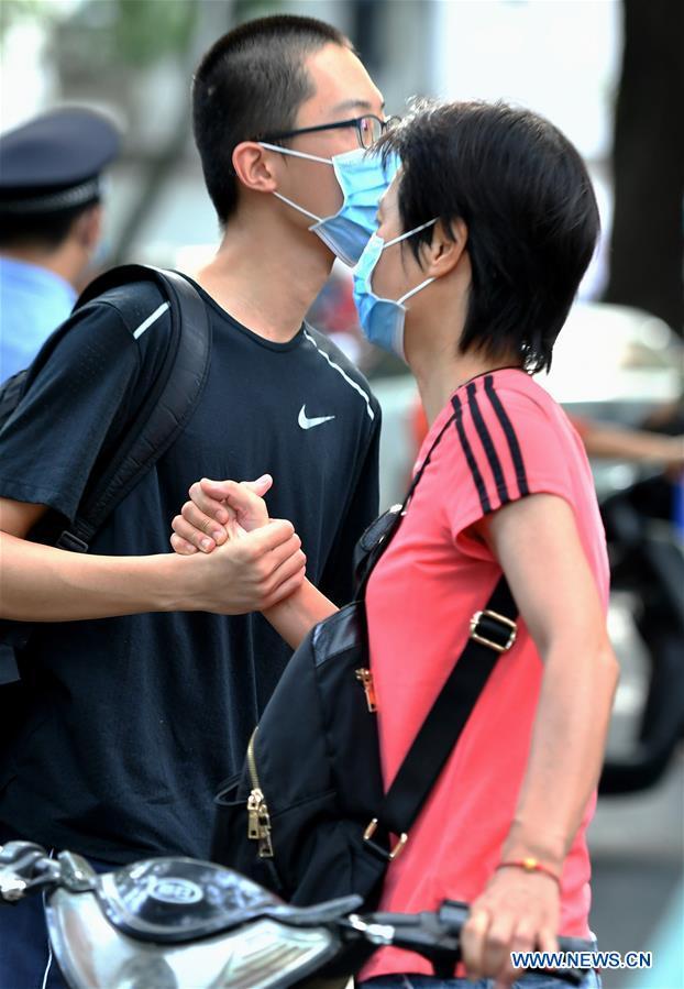 Μια μητέρα ενθαρρύνει έναν εξεταζόμενο έξω από τον χώρο εξετάσεων στο 2ο Λύκειο στο Φουτζόου, πρωτεύουσα της επαρχίας Φουτζιέν της ΝΑ Κίνας, στις 7 Ιουλίου 2020.(Xinhua / Wei Peiquan)<br>