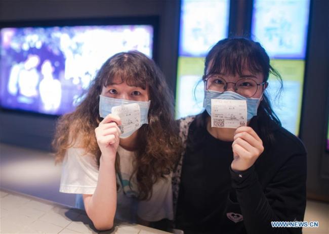 Οι θεατές δείχνουν τα εισιτήριά τους σε έναν κινηματογράφο στο Γουχάν, στην επαρχία Χουμπέι της κεντρικής Κίνας, στις 20 Ιουλίου 2020. (φωτογραφία/ Xinhua)
