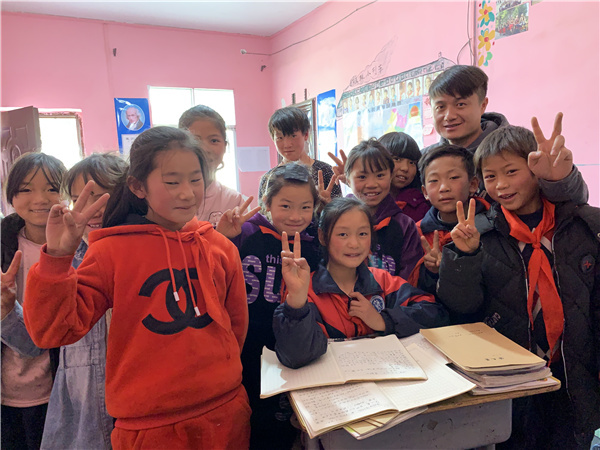 Ο Γκου Για ποζάρει για μια φωτογραφία με τους μαθητές του μετά το μάθημα. [Η φωτογραφία παρέχεται στην China Daily)