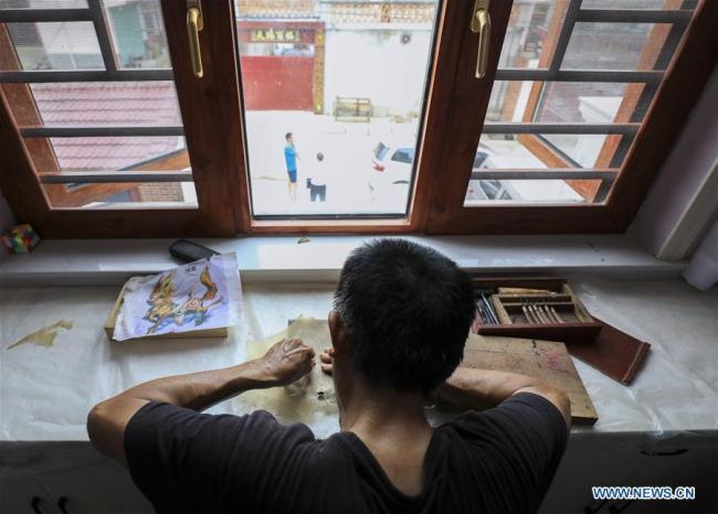 Ο καλλιτέχνης του θεάτρου σκιών Τσάι Σαντσούν, φτιάχνει μια φιγούρα στο σπίτι στο χωριό Ντουτσούν της κομητείας Γιανγκσιάν, που βρίσκεται στην επαρχία Σαανσί της βορειοδυτικής Κίνας, 1η Αυγούστου 2020. (φωτογραφία/Xinhua)