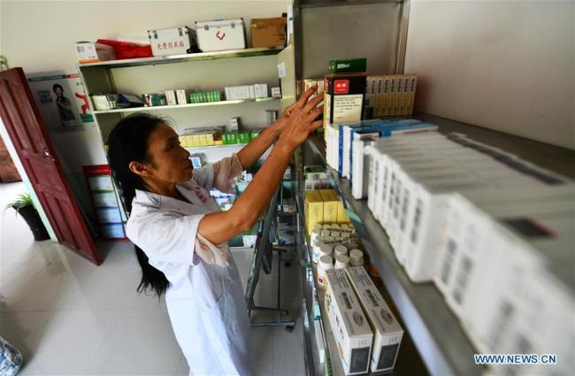 Η Λουό Μου επιλέγει φάρμακα για τους χωρικούς που φροντίζει στην κλινική στο χωριό Τσουιγουέι της κομητείας Λονγκλί, στην αυτόνομη περιφέρεια Τσιενάν Μπουγί-Μιάο στην επαρχία Γκουιτζόου της νοτιοδυτικής Κίνας, 18 Αυγούστου 2020.