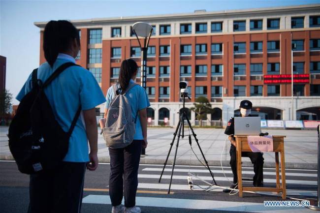 Μαθητές παιρνούν από έλεγχο της θερμοκρασίας στο γυμνάσιο Νταογού του Λιουγιάνγκ στην πόλη Τσανγκσά, πρωτεύουσα της επαρχίας Χουνάν στην κεντρική Κίνα, στις 31 Αυγούστου 2020.