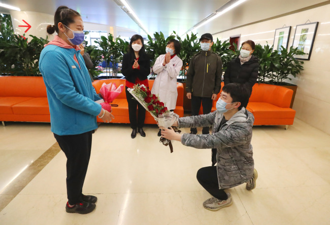 Ο Γιαο Νινγκσίν προσφέρει λουλούδια στην Τσούι στο νοσοκομείο του Πεκίνου στις 22 Απριλίου 2020<br>
