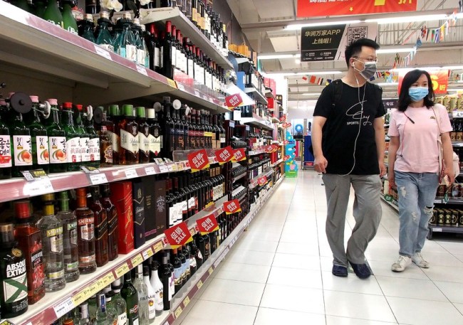 Οι καταναλωτές περπατούν πέρα από την περιοχή εισαγόμενων προϊόντων ενός σούπερ μάρκετ στη Σαγκάη, ανατολική Κίνα, 14 Ιουλίου 2020. (φωτογραφία / Xinhua)